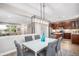 Bright dining room with modern light fixture open to the kitchen with seating for six at 2908 N Florence St, Denver, CO 80238