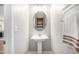 Neat powder room featuring a pedestal sink, decorative mirror, and towel rack at 2908 N Florence St, Denver, CO 80238