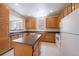 Bright kitchen featuring an island, wood cabinets, and white appliances at 1521 Vine St # 101, Denver, CO 80206