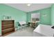 Craft room or bedroom with mint colored walls, natural light, and craft table at 11285 Iola St, Commerce City, CO 80640