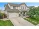 Charming two-story home with a well-maintained lawn, covered porch, attached two-car garage and concrete driveway at 11285 Iola St, Commerce City, CO 80640