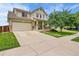 Charming two-story home with a well-maintained lawn, covered porch, attached two-car garage and concrete driveway at 11285 Iola St, Commerce City, CO 80640