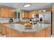 Spacious kitchen featuring an island, wooden cabinetry, stainless steel appliances and natural light at 11285 Iola St, Commerce City, CO 80640