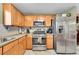 Well-equipped kitchen with stainless steel appliances, wooden cabinetry, and ample counter space at 11285 Iola St, Commerce City, CO 80640