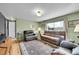 Cozy living room with hardwood floors, a comfortable brown sofa, and a large window providing natural light at 11285 Iola St, Commerce City, CO 80640