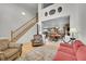 Inviting living room showcasing hardwood floors, a staircase, and an open floor plan leading to the kitchen and dining area at 11285 Iola St, Commerce City, CO 80640
