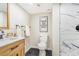 Stylish bathroom featuring a wood vanity, black fixtures, and a walk-in shower with marble-patterned tile at 3713 S Ensenada St, Aurora, CO 80013