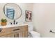 Updated half bath featuring a wood vanity, modern fixtures, and stylish decor at 3713 S Ensenada St, Aurora, CO 80013