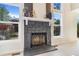 Close-up of the stone fireplace with a decorative mantle, flanked by bright windows at 3713 S Ensenada St, Aurora, CO 80013