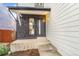 An inviting front entrance featuring a stone accent wall and modern black door at 3713 S Ensenada St, Aurora, CO 80013