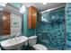 Modern bathroom featuring blue tiled shower, sink with new fixtures, and wood storage at 1470 S Quebec Way # 245, Denver, CO 80231
