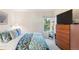 Bright bedroom with leafy patterned bedding, a window, and wood storage unit at 1470 S Quebec Way # 245, Denver, CO 80231