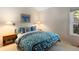 Comfortable bedroom with cozy floral patterned bedding, a window view, and bedside tables at 1470 S Quebec Way # 245, Denver, CO 80231