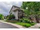 Charming two-story home with a wooden porch and lush landscaping surrounding the walkway at 1470 S Quebec Way # 245, Denver, CO 80231