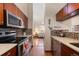 Modern kitchen featuring stainless steel appliances, custom cabinetry, and a view into the living room at 1470 S Quebec Way # 245, Denver, CO 80231