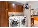 Organized laundry room featuring front load washer and dryer under cabinets, natural lighting at 1470 S Quebec Way # 245, Denver, CO 80231
