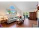 Spacious living room with vaulted ceiling, large windows, hardwood floors, and comfortable seating area at 1470 S Quebec Way # 245, Denver, CO 80231