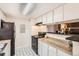 Well-lit kitchen featuring white cabinets, modern appliances, and a pass-through to the living area at 18091 E Kentucky Ave # 202, Aurora, CO 80017