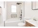 Chic bathroom features a tub, shower, decorative niche, and modern black fixtures with a sink and vanity at 930 S Lowell Blvd, Denver, CO 80219
