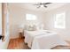 Bright bedroom featuring hardwood floors, white walls, a ceiling fan, and natural light from two windows at 930 S Lowell Blvd, Denver, CO 80219