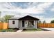 Attractive home with a manicured lawn, fence, and charming front porch with seating at 930 S Lowell Blvd, Denver, CO 80219