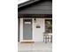 Charming home with a gray front door, welcome mat, and cozy seating area on the porch at 930 S Lowell Blvd, Denver, CO 80219