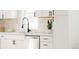 Modern kitchen with stainless steel dishwasher and white cabinets and backsplash at 930 S Lowell Blvd, Denver, CO 80219