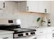 Modern kitchen featuring stainless steel stove, white countertops, and decorative accents at 930 S Lowell Blvd, Denver, CO 80219