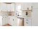 Updated kitchen featuring white cabinets, stainless steel dishwasher, and modern fixtures at 930 S Lowell Blvd, Denver, CO 80219