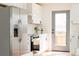Modern kitchen features stainless steel refrigerator, white cabinets, and a glass door at 930 S Lowell Blvd, Denver, CO 80219