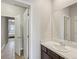 Bathroom with a single vanity, white countertops, a tile floor, and a doorway to another room at 11999 S Stroll Ln, Parker, CO 80138