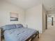 Bedroom with a large bed, a white nightstand, a hallway view, and neutral colored walls at 11999 S Stroll Ln, Parker, CO 80138