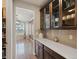 Dining area with hardwood floors, modern cabinetry with glass doors, and a view of the dining room with a stylish chandelier at 11999 S Stroll Ln, Parker, CO 80138