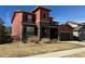 Striking two-story home with red siding, stone accents, and manicured front yard at 11999 S Stroll Ln, Parker, CO 80138