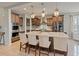 A gourmet kitchen features an oversized island, pendant lighting, stainless appliances, and custom cabinets at 11999 S Stroll Ln, Parker, CO 80138