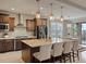 A gourmet kitchen features an oversized island, pendant lighting, stainless appliances, and custom cabinets at 11999 S Stroll Ln, Parker, CO 80138