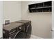 Modern laundry room with front loading washer and dryer, floating shelf, and neutral colored walls at 11999 S Stroll Ln, Parker, CO 80138