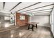 Open dining area with exposed beam ceiling, brick accent wall, and modern lighting fixtures at 6598 S Logan St, Centennial, CO 80121