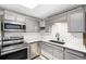 Modern kitchen featuring stainless steel appliances, gray cabinets, and white subway tile backsplash at 6598 S Logan St, Centennial, CO 80121
