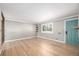 Bright living room featuring hardwood floors, a teal door, and large windows with natural light at 6598 S Logan St, Centennial, CO 80121