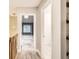Bright hallway featuring a decorative hanging light and a view into a bedroom with a large window at 11155 W 17Th Ave # 103, Lakewood, CO 80215