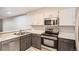 Well-lit kitchen with stainless steel appliances, modern oven, and white and gray cabinets at 11155 W 17Th Ave # 103, Lakewood, CO 80215