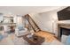 Open-concept living room with hardwood floors, a fireplace, and a staircase leading to the upper level at 11155 W 17Th Ave # 103, Lakewood, CO 80215