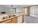 Inviting kitchen featuring a double sink with laminate countertops and views of the living room and fireplace at 3375 Boulder Cir # 204, Broomfield, CO 80023