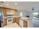 Modern kitchen featuring stainless steel appliances, light wood cabinets, and an open view into the living room at 3375 Boulder Cir # 204, Broomfield, CO 80023