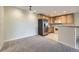 Open-concept kitchen featuring stainless steel refrigerator and ample cabinet space next to carpeted living area at 3375 Boulder Cir # 204, Broomfield, CO 80023