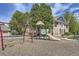 Community playground featuring swings, a slide, and other play equipment, surrounded by lush landscaping at 3375 Boulder Cir # 204, Broomfield, CO 80023