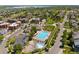 Aerial view showcasing a community pool, surrounding homes, green spaces, and a scenic lake in the distance at 8367 Devinney St, Arvada, CO 80005