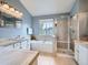 Relaxing bathroom featuring a soaking tub, walk-in shower, dual vanities, and tiled floors at 8367 Devinney St, Arvada, CO 80005