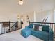 Upstairs bonus room with view of a bedroom, featuring a cozy sofa and black iron railing at 8367 Devinney St, Arvada, CO 80005